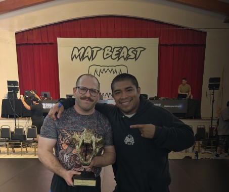 Avi Cohn with a competitor holding a MatBeast trophy